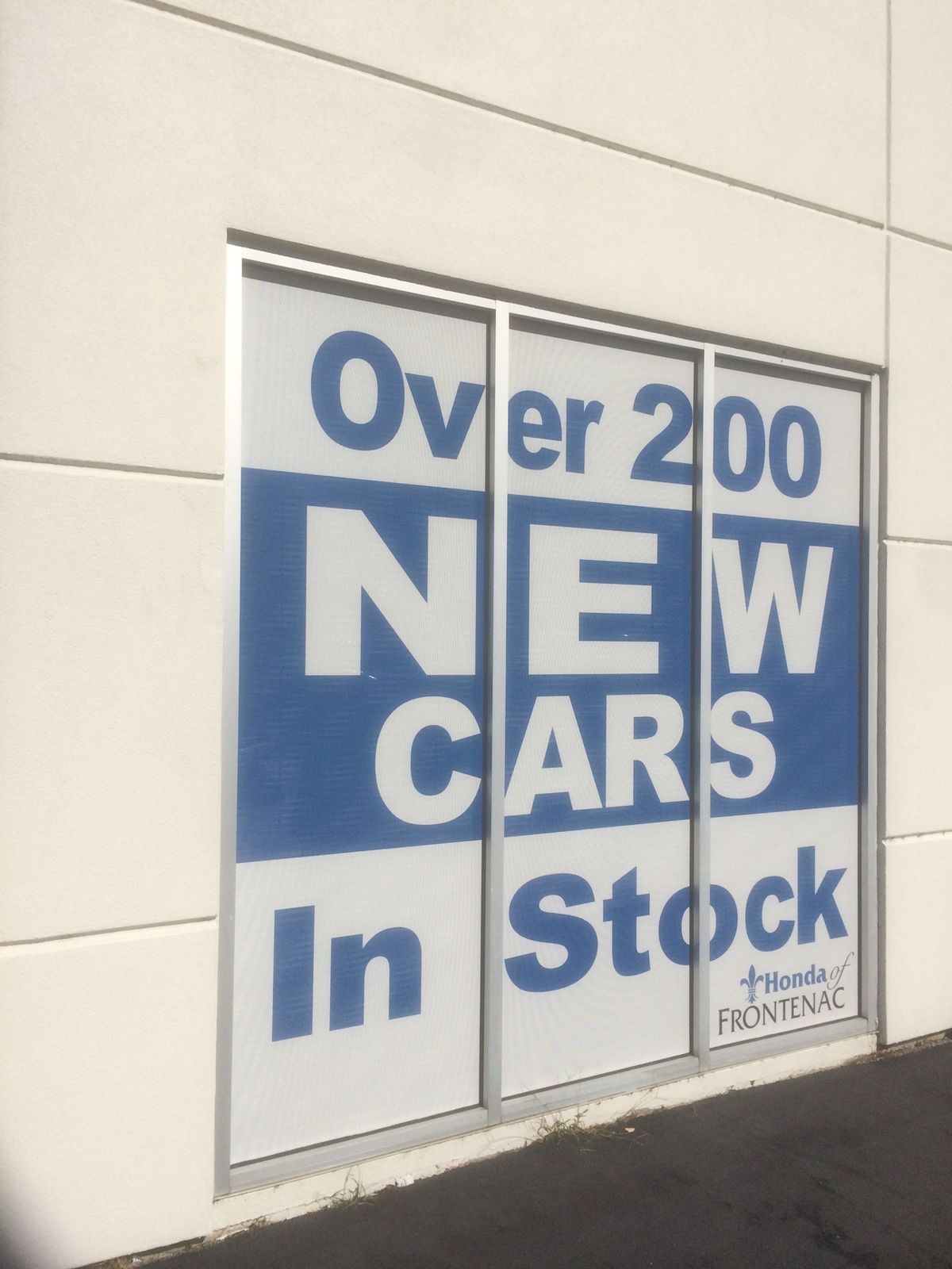 A window graphic reading Over 200 New Cars In Stock