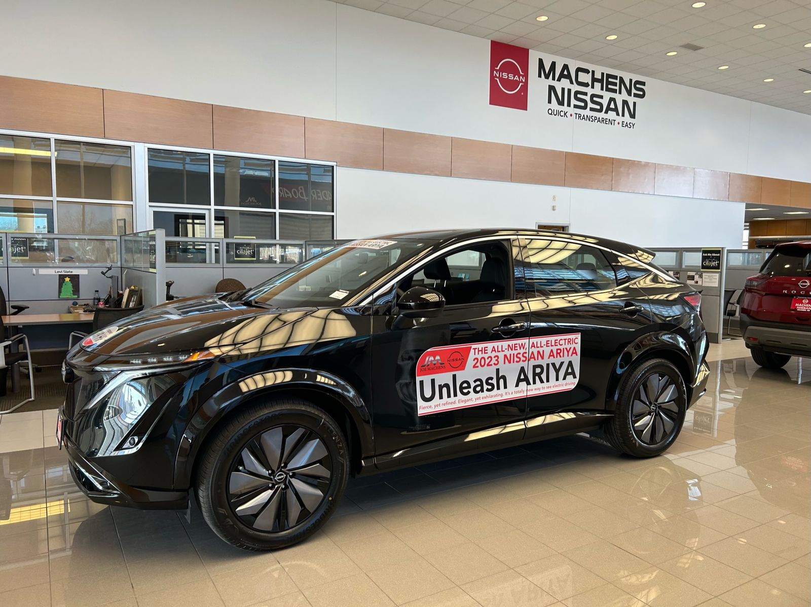 Body sides on a Nissan ARIYA in the showroom reading Unleash ARIYA