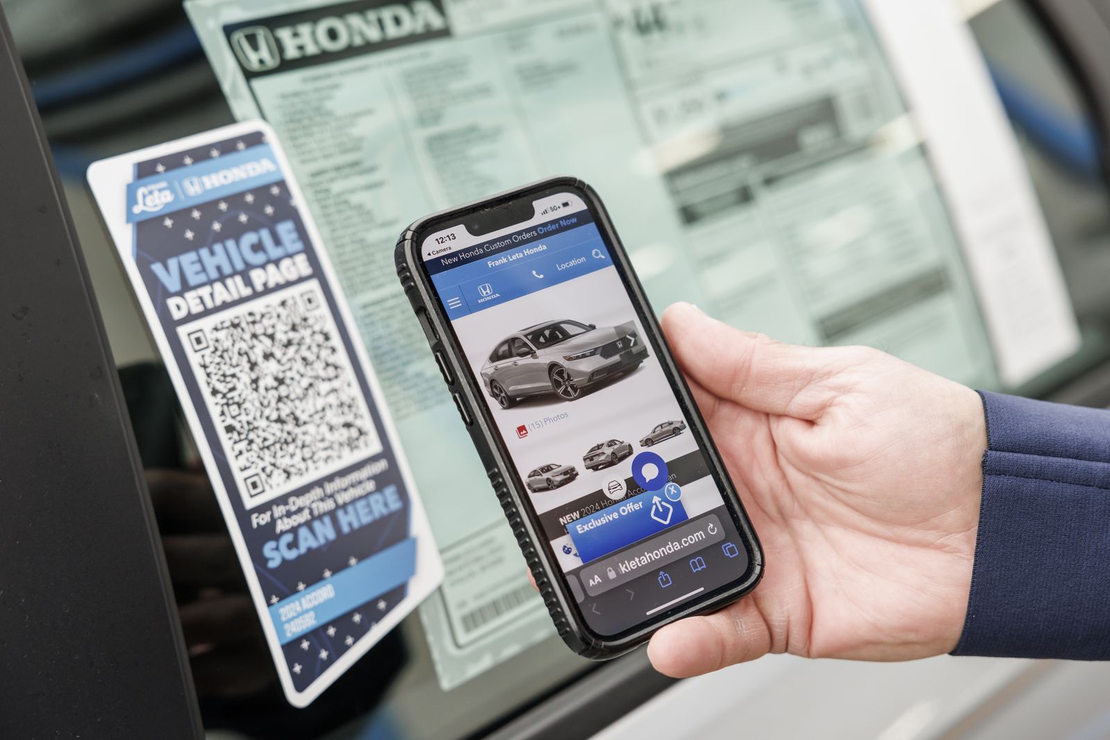 A phone opening the car's own page from the QR placard on the glass
