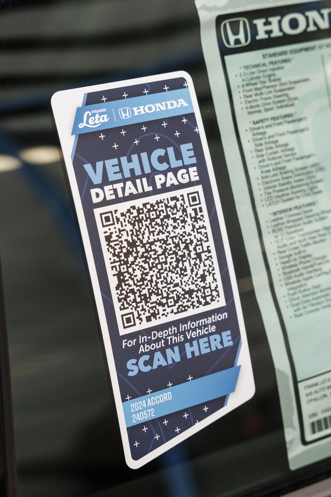 A Vehicle Detail Page QR placard on the glass beside the window sticker