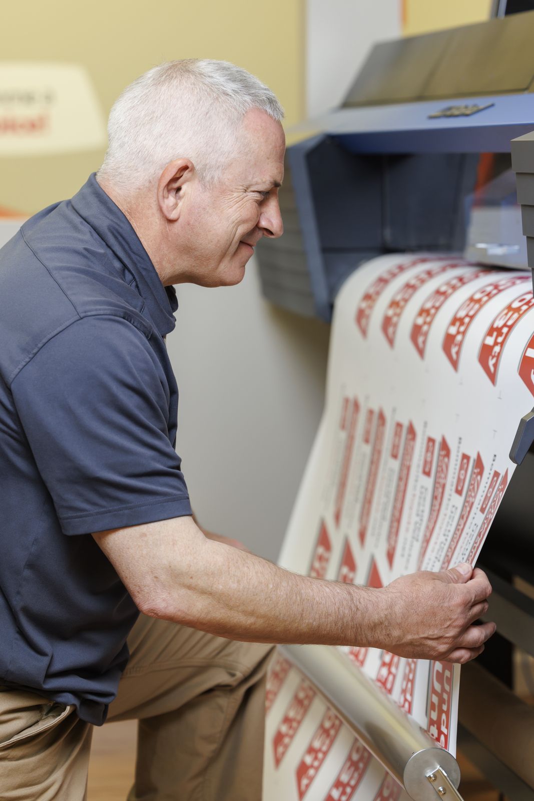 Pep checking a run of windshield banners as they come off the printer in our shop