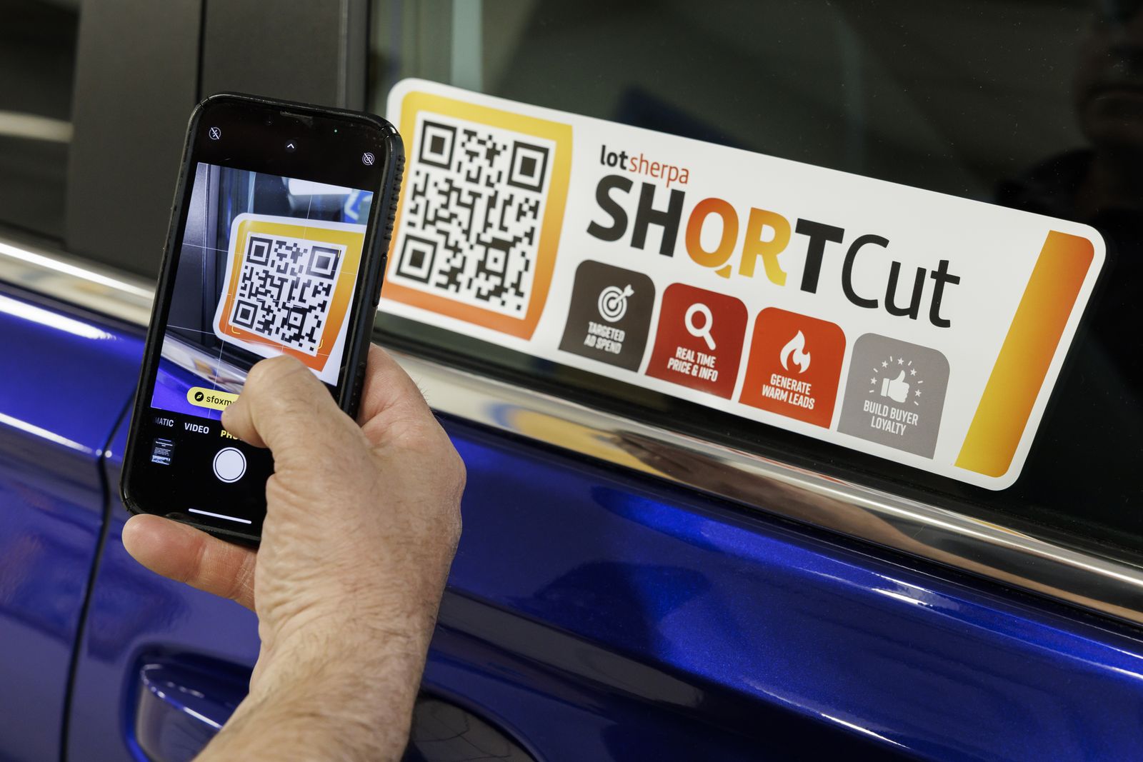A phone camera scanning the ShortCut placard on a car's door glass