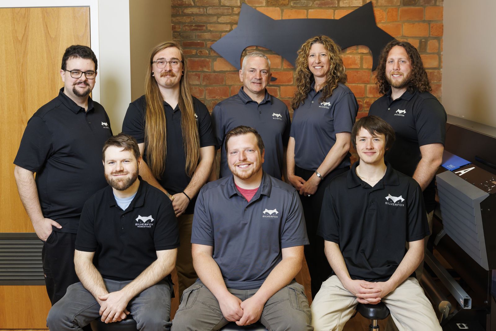 Our team in front of the fox wall at our shop