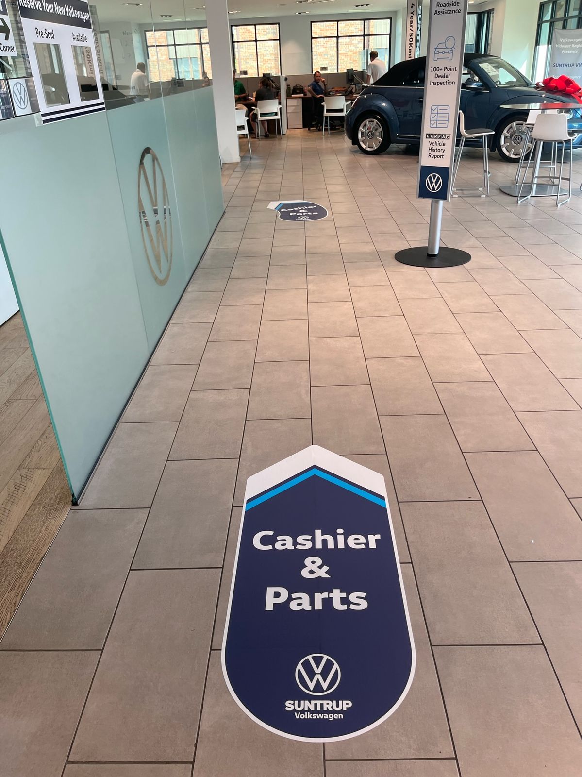 A floor graphic pointing to Cashier and Parts