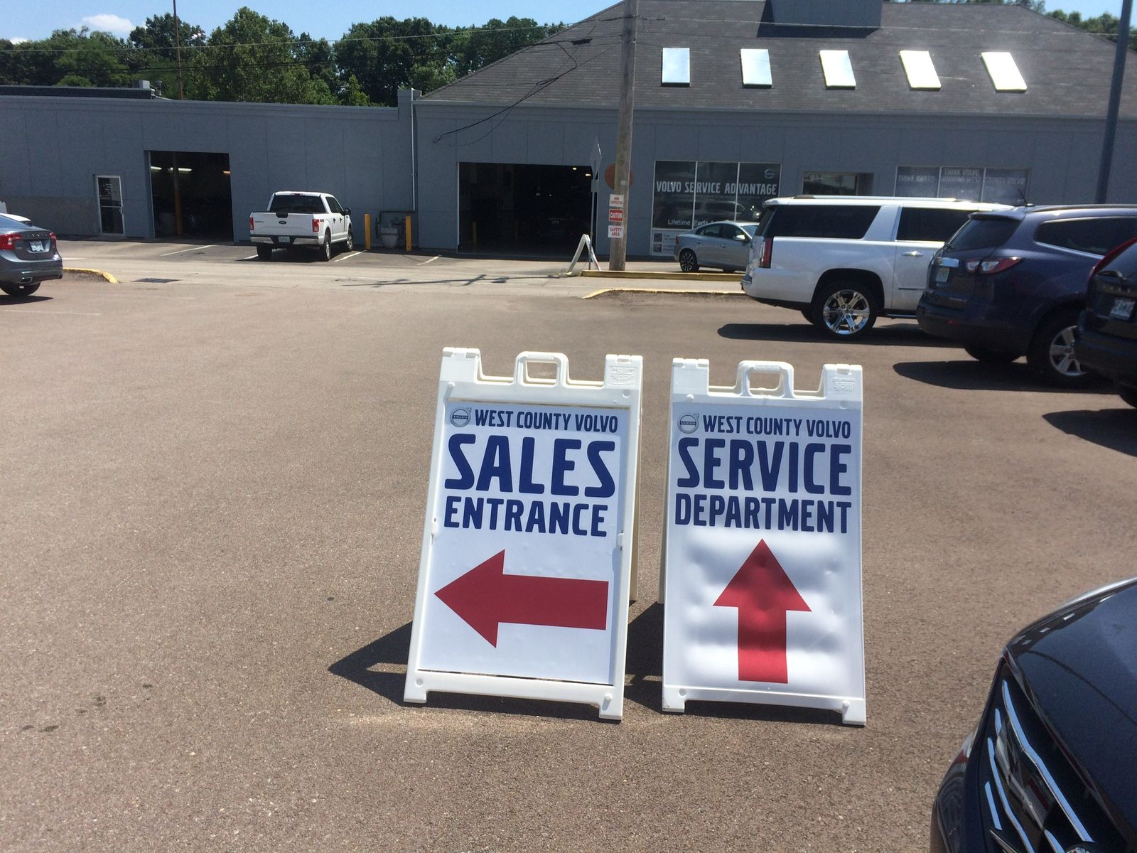 A-frame signs pointing to the Sales Entrance and the Service Department